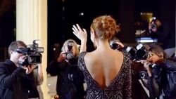 Celebrity walking red carpet and waving to paparazzi at red carpet event Stock Footage