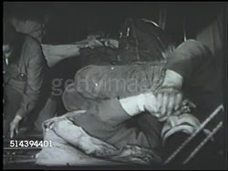 1943: ALEUTIAN ISLANDS CAMPAIGN: UNITED STATES ARMY: VS U.S. Army tents, camp, in Amchitka, Alaska, INT soldiers during down time inside tents, playing harmonica (partial SOT), writing, EXT tent w/ smoking rising from small chimney top. WWII Instructional Video