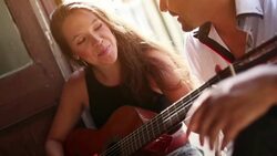 She plays guitar and sing for him Stock Footage