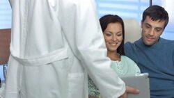 HD DOLLY: Doctor Showing Ultrasound Scan To A Couple Stock Footage