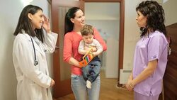Doctors comforting a young patient with mother Stock Footage