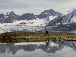 WS View of girl walking on tundra with snowcapped mountains in background / Svalbard, Spitsbergen, Norway Stock Footage