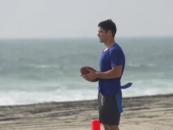 A group of guys playing flag football on the beach. - Slow Motion Stock Footage