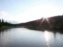 Time lapse view of sun rising above mountain lake Stock Footage