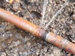 Frozen Cracked Copper Water Main Pipe Leaking Below Ground Stock Footage