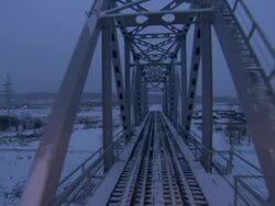 Wide Shot push-in - View from a train crossing a snow-covered truss bridge. / Yakutsk, Russian Federation Stock Footage
