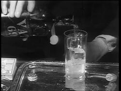 B/W 1933 hands of man pouring from bottle labeled 'Vat 69' into glass / end of Prohibition Stock Footage