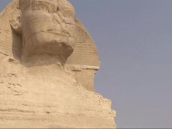 Medium Close Up, crane pan-right tilt-down - The Sphinx stands majestically in the desert / Egypt Stock Footage