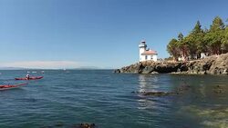 The lighthouse at Lime Kiln State Park on San Juan Island on a sunny day. Stock Footage