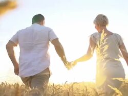 HD SUPER SLOW-MOTION: Couple Running In Field At Sunset Stock Footage