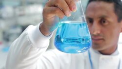 Scientist examining beaker in laboratory Stock Footage