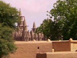 Scenic shot of a mosque in a Mali village from a boat on the Niger River Stock Footage