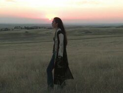 MS PAN American Indian young woman standingon great plains in grass near at sunset time / Pine Ridge, South Dakota, United States    Stock Footage