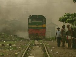 WS View of train track running through shanty town and burning plastic with people / Lagos, Nigeria Stock Footage