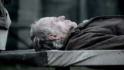 A corpse riddled with Black Plague lies beside a fire. Stock Footage