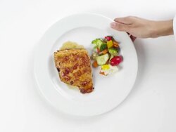 CU Woman hand entering setting down round white plate with grilled salmon fish and side of vegetables / Omaha, Nebraska, United States Stock Footage