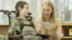 Woman Reads to Child with Physical Disability Stock Footage