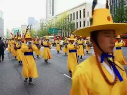 MS Shot of traditional Korean costume parade carrying sedan chair through city hall plaza / Seoul, South Korea Stock Footage