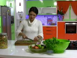 Pretty girl in her kitchen cutting vegetable Stock Footage