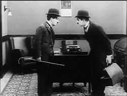 B/W 1916 Charlie Chaplin and similarly dressed man (Lloyd Bacon) mirroring each other's actions Stock Footage