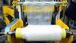 panning: rolling up blown plastic film by extruder machine Stock Footage