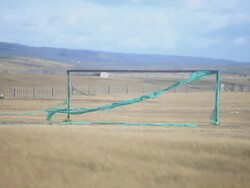 MS Rectangular structure with green fabric attached and blowing in wind in yellow vast plain Stock Footage