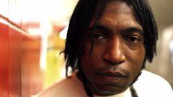 Street musician stares at camera on New York City subway platform as train passes by Stock Footage