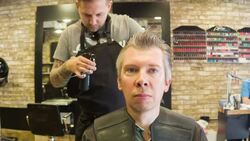 Male Hair stylist combing male clients hair Stock Footage