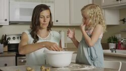 Medium panning shot of mother and daughter rolling cookie dough / Orem, Utah, United States Stock Footage