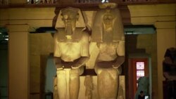 Two large Egyptian statues tower over museum patrons. Stock Footage