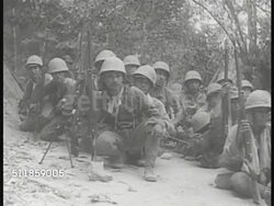 1941: JAPANESE FORCES LAND IN PHILIPPINES: Soldiers wading to shore. WS Soldiers grouped together, crouching on beach. VS US Tank treads. Soldiers trotting along urban roadside. VS Soldiers hiding in jungle. US Tank moving up jungle pathway.  Invasion Instructional Video