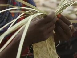 woman with tattooed face braiding straw Stock Footage