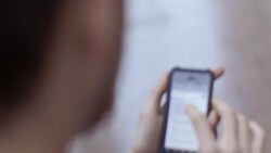 Young couple search on smartphone while walking through urban downtown Stock Footage