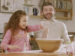 MS Shot of Daddy & daughter sieving flour in kitchen / London, United Kingdom  Stock Footage