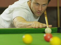 L/A CU young man shooting pool billiards, balls in foreground, shooting to camera Stock Footage