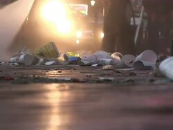 Medium Shot Low Angle - Trash and street being sprayed by water hose / New Orleans Louisiana Stock Footage