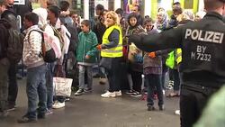 German Child Handing Out Toys to Arriving Refugees News Clip