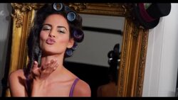 A woman with hair in roller blows a kiss to camera Stock Footage