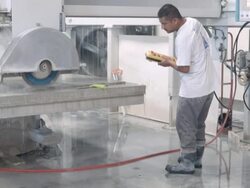 WS TU water dripping from table of computer controlled gantry saw as operator holds control in his hand and watches marble cutting process  / Thousand Palms, California, USA Stock Footage