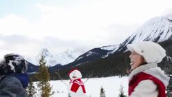 Brother and sister spinning under falling snow Stock Footage