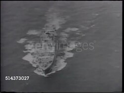 1928: AVIATION: GERMAN RIGID AIRSHIP: WS Graf Zeppelin dirigible in flight, WS 'Graf Zeppelin' name on side near end. AERIAL WS Passenger ship on ocean. MS Passengers waving from Zeppelin windows. TU (POV UNDER) Graf Zeppelin passing overhead. Instructional Video