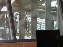 Men in suits walk along a raised walkway in a modern courthouse. Stock Footage