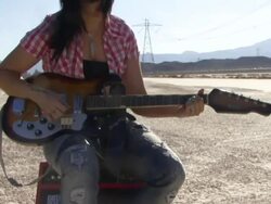 Female playing guitar in desert Stock Footage