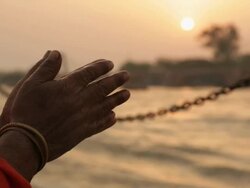 Close-up of a sage's hands worshipping at riverbank, Ganges River, Haridwar, Uttarakhand, India Stock Footage