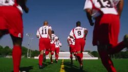 A soccer team jogs along a soccer field. Stock Footage
