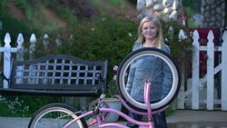 MS Young girl fixing her bicycle Stock Footage