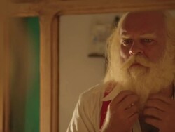 M/S Santa looking at a mirror and stroking his moustache and beard Stock Footage