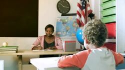 HD: Little Boy doing his work in front of Teacher Stock Footage