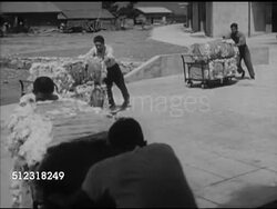 1953: FORMOSA, TAIWAN: JCRR FUNDING OPENS MILL: HA Angled WS Six men pushing bales of cotton stacked on rolling carts, past warehouses, into plant, VS Women workers monitoring spinning machines, large spools spinning, CU Women concentrating on work. Instructional Video