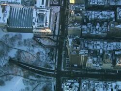 Aerial flying over Central Park, Metropolitan Museum, and 5th avenue in Manhattan looking directly down at park and streets covered in snow NYC Stock Footage